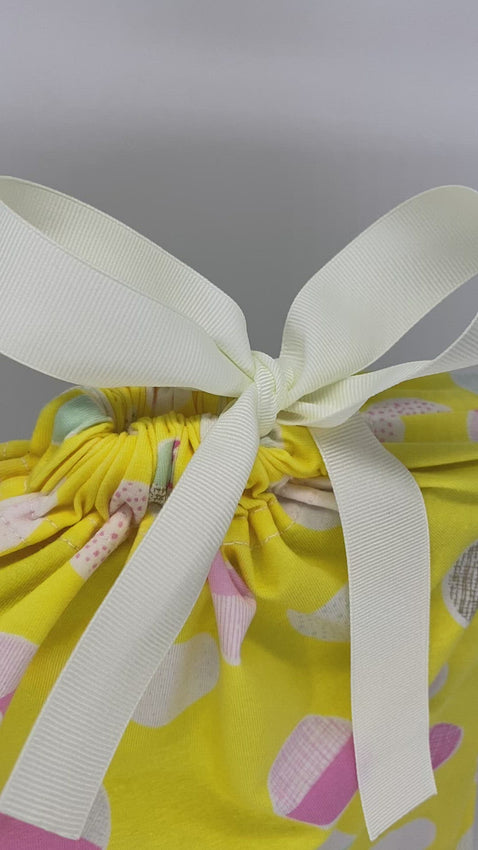 Yellow and dots reusable and sustainable fabric gift bag in size medium with a white ribbon  video