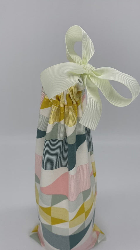 wine fabric gift bag in an abstract shapes yellow, green and pink pattern with a ribbon