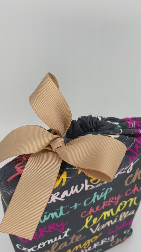 video of small fabric gift bag with colorful ice-cream names on it and a ribbon