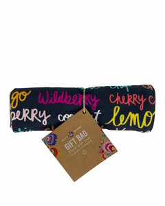 large sustainable and reusable fabric gift bag with colorful ice-cream names on it and a ribbon